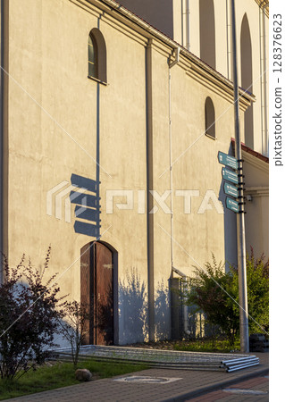 Old style direction signs casting shadow on near by wall Old style direction signs casting shadow on near by wall 128376623