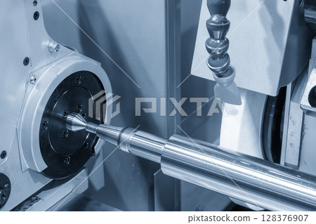 The CNC surface grinding machine working with cylindrical shaft parts. 128376907