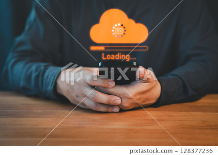 Person holding a smartphone with a glowing orange cloud upload icon and loading progress bar, representing cloud computing, data transfer, internet of things, and digital technology. 128377236