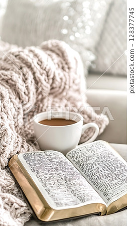 A book is open to a page with a cup of coffee next to it 128377745