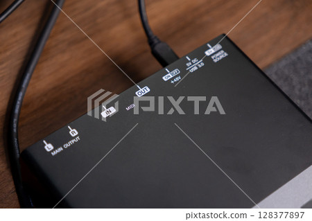 Black professional audio interface device showcasing Main Output, MIDI InOut ports, USB 3.0, and 48V power labels, essential for modern home studio music production setups Black professional audio interface device showcasing Main Output, MIDI InOut ports, USB 3.0, and 48V power labels, essential for modern home studio music production setups 128377897