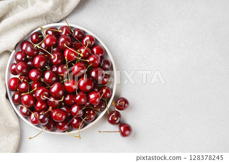 White plate full of fresh ripe red sweet cherry and linen napkin on white bakground with copy space White plate full of fresh ripe red sweet cherry and linen napkin on white bakground with copy space 128378245