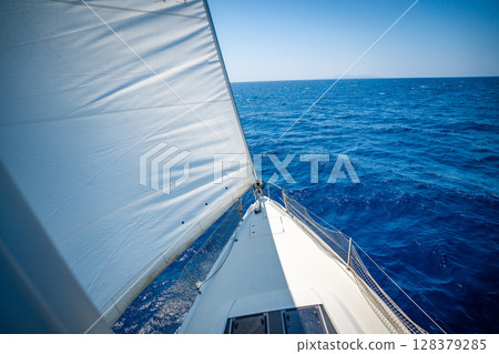 View from the mast down to the bow of a sailing yacht moving under full sails near Croatia. Freedom, adventure, yachting lifestyle and dynamic sea travel. View from the mast down to the bow of a sailing yacht moving under full sails near Croatia. Freedom, adventure, yachting lifestyle and dynamic sea travel. 128379285