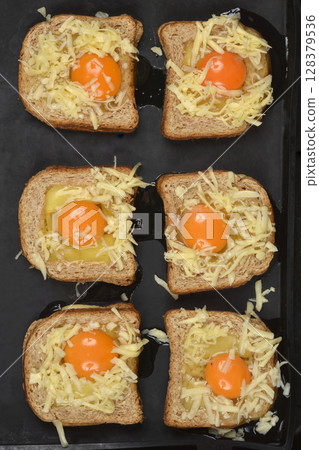 Toast with cut-out centers filled with raw eggs 128379536