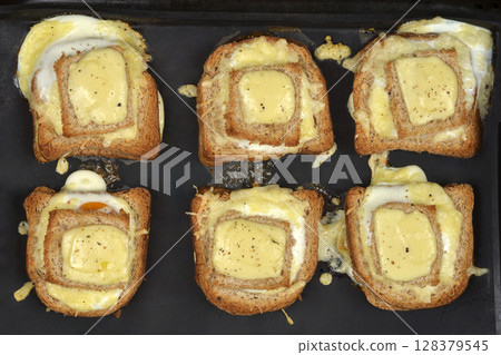 Baked egg-in-toast with melted cheese Baked egg-in-toast with melted cheese 128379545