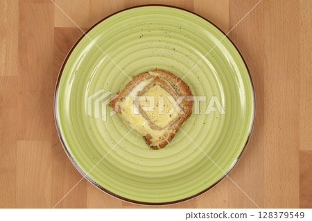 Baked egg-in-toast with melted cheese 128379549