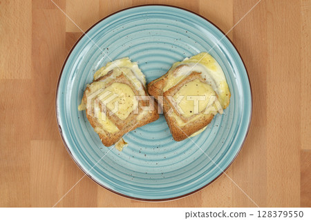 Baked egg-in-toast with melted cheese 128379550