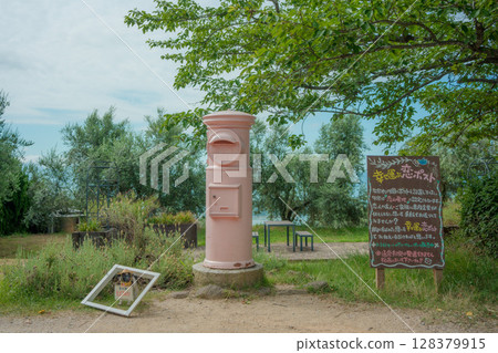 A postbox in the park. A pink retro postbox and scenery standing in an olive field. Postbox at Ushimado Olive Garden. A postbox in the park. A pink retro postbox and scenery standing in an olive field. Postbox at Ushimado Olive Garden. 128379915