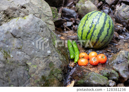 Watermelon, cucumber, and tomato chilled in a mountain stream 128381236