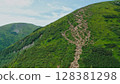 Aerial view of young tourists walking along a mountain trail with backpacks to the top of the mountain. Hiking, climbing, traveling, trekking, backpacking. 128381298