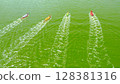 Aerial view of the rougher competition between the teams on rowing boats on the pond. Rowboats with teams of rude people rushing along the water surface to the finish line. 128381316