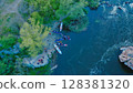 Aerial view of rowers on boats docking to the shore. Kayaks heading to the shore after the competition on a turbulent mountain river. 128381320
