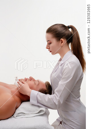 Woman provides relaxing massage in a serene beauty studio setting 128381665