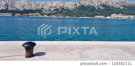 A black bollard on a concrete 128382111