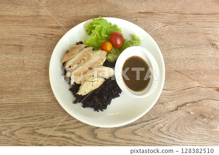 grilled slice chicken black pepper on riceberry with tomato and lettuce on plate dipping Thai spicy tamarind sauce 128382510