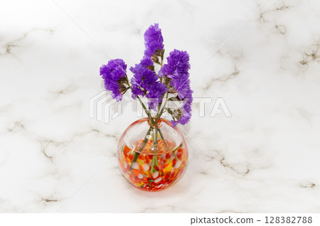 暖色玻璃花瓶中央插著紫色補血草花 暖色玻璃花瓶中央插著紫色補血草花 128382788