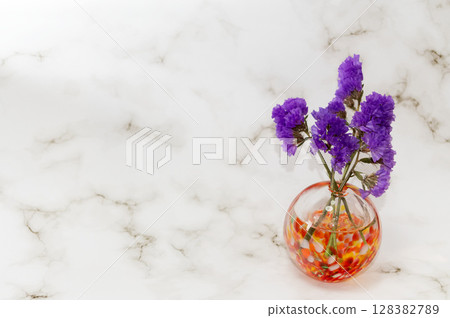 右側暖色玻璃花瓶中插著紫色補血草 128382789