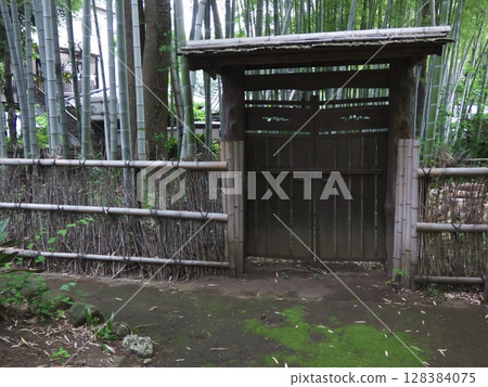 The elegant brushwood fence and traditional gate decorating the garden of the Nichiren sect Myofukuji temple 128384075