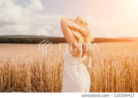 Woman wheat field. Agronomist, Woman farmer check golden ripe barley spikes in cultivated field. A woman is holding a bunch of wheat in her arms. Woman wheat field. Agronomist, Woman farmer check golden ripe barley spikes in cultivated field. A woman is holding a bunch of wheat in her arms. 128384417