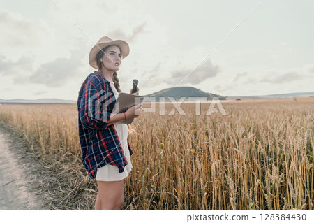 Young Woman in a Wheat Field with a Tablet Young Woman in a Wheat Field with a Tablet 128384430