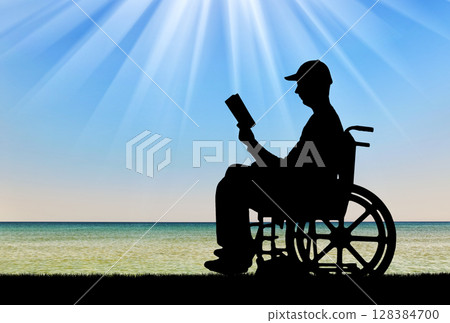 Silhouette of a disabled person in a wheelchair reading a book Silhouette of a disabled person in a wheelchair reading a book 128384700