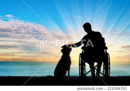 Silhouette of a disabled man in a wheelchair stroking his dog Silhouette of a disabled man in a wheelchair stroking his dog 128384701