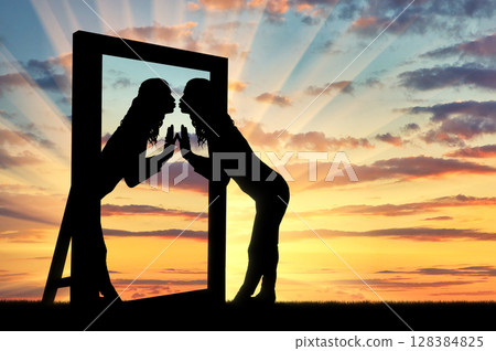 Woman is kissing her reflection in the mirror 128384825
