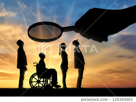 Employer's hand looks through the magnifying glass to an invalid in a wheelchair waiting for an interview for work 128384865