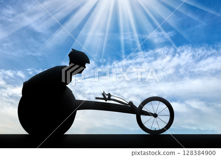 Silhouette of sportsman disabled in a racing wheelchair Silhouette of sportsman disabled in a racing wheelchair 128384900