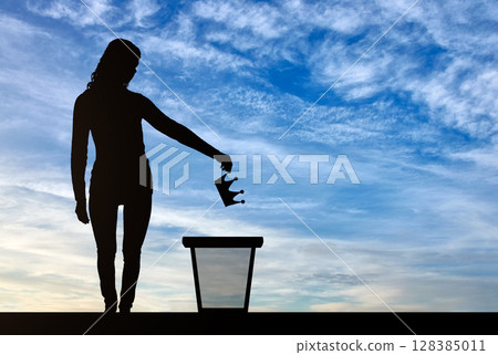 Silhouette of a woman throwing a crown in a garbage bin Silhouette of a woman throwing a crown in a garbage bin 128385011