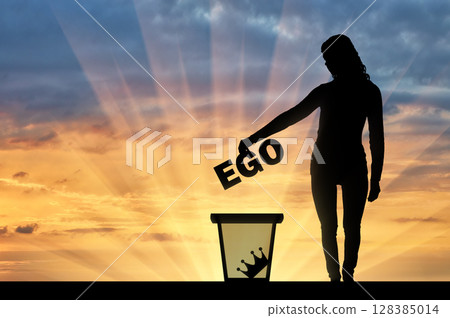 Silhouette of a woman throws the word ego into the garbage bin 128385014