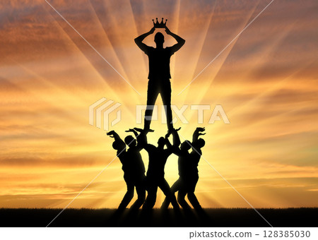 Silhouette of a selfish and narcissistic man dressing a crown, he stands on a crowd of men Silhouette of a selfish and narcissistic man dressing a crown, he stands on a crowd of men 128385030