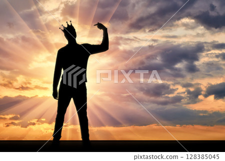 A silhouette of a narcissistic man with a crown on his head shows his finger on himself. He tries to attract attention A silhouette of a narcissistic man with a crown on his head shows his finger on himself. He tries to attract attention 128385045