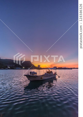 A small fishing boat floating quietly in an Okinawa fishing port A small fishing boat floating quietly in an Okinawa fishing port 128386326