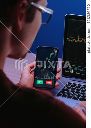Close up real-time market chart with price indicators on smartphone Close up real-time market chart with price indicators on smartphone 128386710
