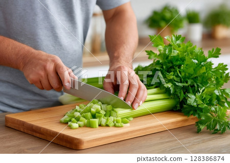 Chopping Fresh Celery on Wooden Cutting Board 128386874