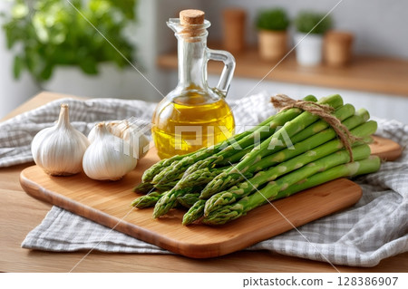 Fresh Asparagus and Garlic with Olive Oil on Wooden Board 128386907