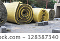 Rolls of thermal insulation material lying on construction site pavement 128387340