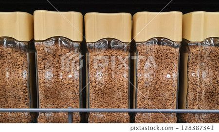 Glass jars of instant coffee filling a supermarket shelf Glass jars of instant coffee filling a supermarket shelf 128387341