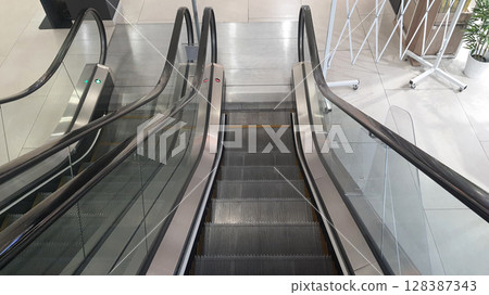 Empty escalators going up and down in a modern shopping mall Empty escalators going up and down in a modern shopping mall 128387343