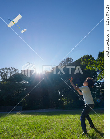 男孩在夏季公園裡享受玩飛機的樂趣 128387625