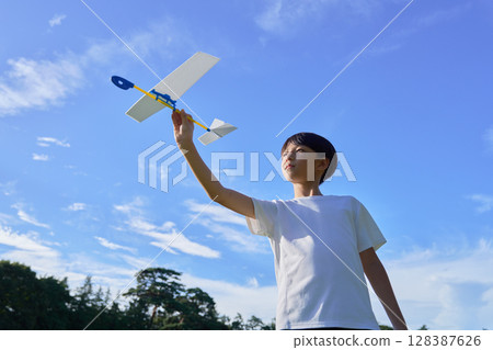 一個男孩拿著模型飛機對著藍天 128387626