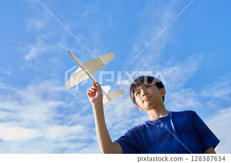 一個男孩駕駛模型飛機飛向藍天 128387634