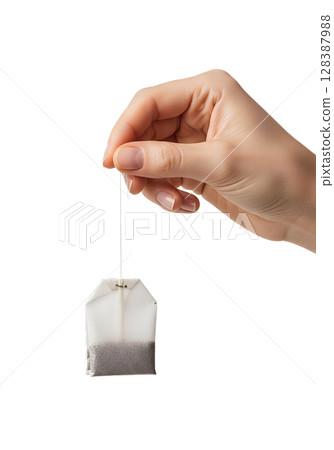 Hand holding tea bag by string isolated on transparent background, herbal infusion concept 128387988