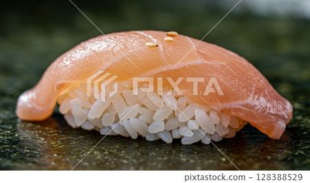 Delicious salmon sushi nigiri with sesame seeds on a dark seaweed surface 128388529