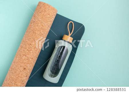 Yoga mat and water bottle on a blue background. 128388531