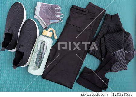 Fitness apparel and accessories laid out on a blue background. Fitness apparel and accessories laid out on a blue background. 128388533