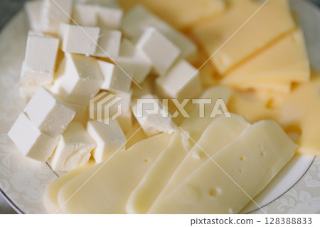 White Feta Cheese Cubes with Yellow Cheese Slices on Plate White Feta Cheese Cubes with Yellow Cheese Slices on Plate 128388833