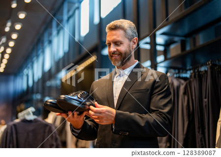 Business man choose elegant footwear in shop. Classic leather shoes for formal look. Formal shoe. Leather footwear. Shop assistant Hispanic man in shoe store hold classic footwear. Shoe store Business man choose elegant footwear in shop. Classic leather shoes for formal look. Formal shoe. Leather footwear. Shop assistant Hispanic man in shoe store hold classic footwear. Shoe store 128389087
