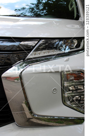 Closeup front view of the white car's LED headlight  128389121